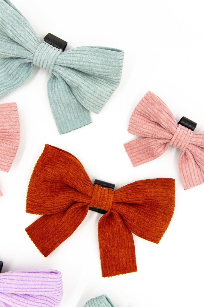 Luxury corduroy and velvet dogs bows in rust, blush pink, sage and lilac colours sit on a white background from Little Ellie Boutique, an Australian dog brand